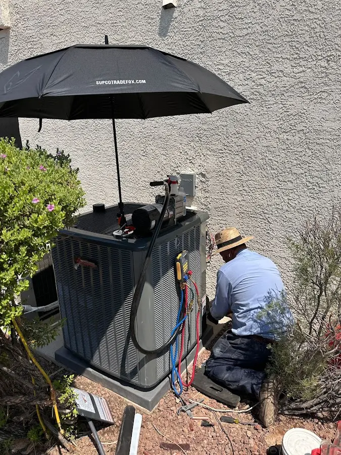 HVAC technician performing outdoor AC maintenance in Connersville